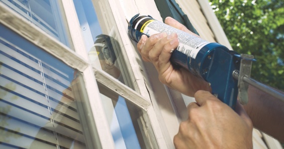person caulking window